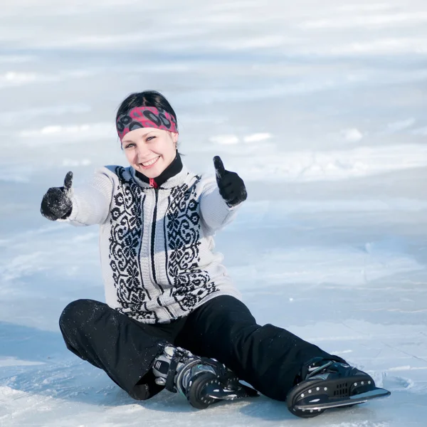 Ice skating kvinna sitter på is — Stockfoto
