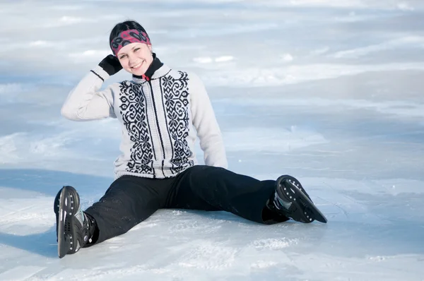 Ice skating woman sitting on ice — Stock Photo, Image