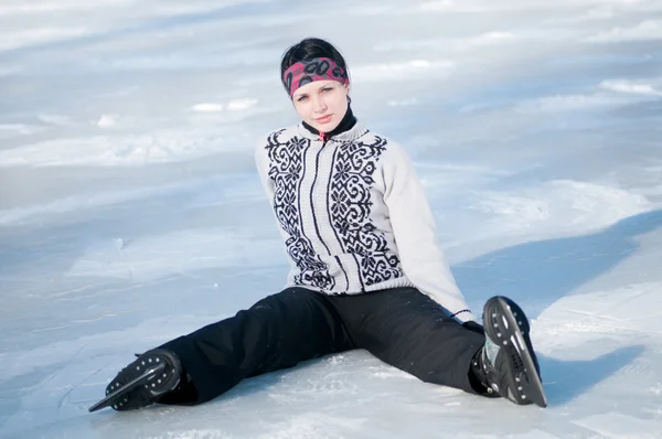 Ice skating woman sitting on ice — Stock Photo, Image