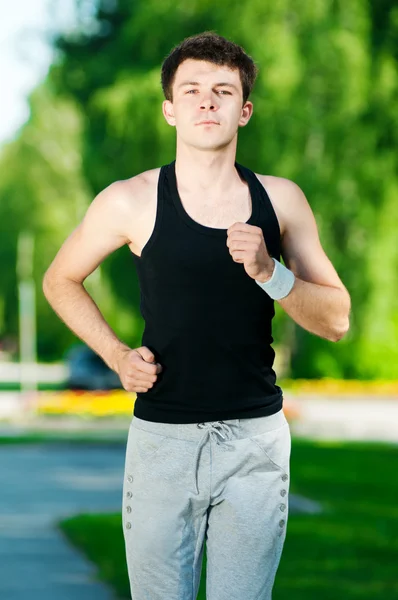 Jeune homme jogging dans le parc — Photo