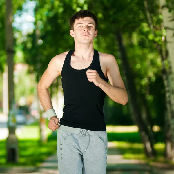 Νεαρός άνδρας τζόκινγκ στο πάρκο — Φωτογραφία Αρχείου