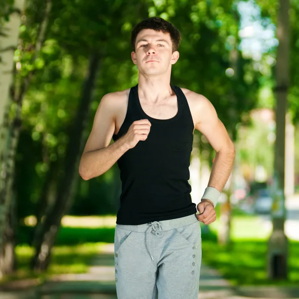 Jonge man joggen in het park — Stockfoto