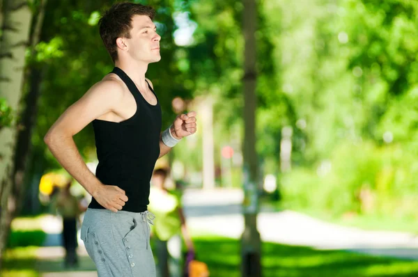 Genç adam parkta koşu — Stok fotoğraf