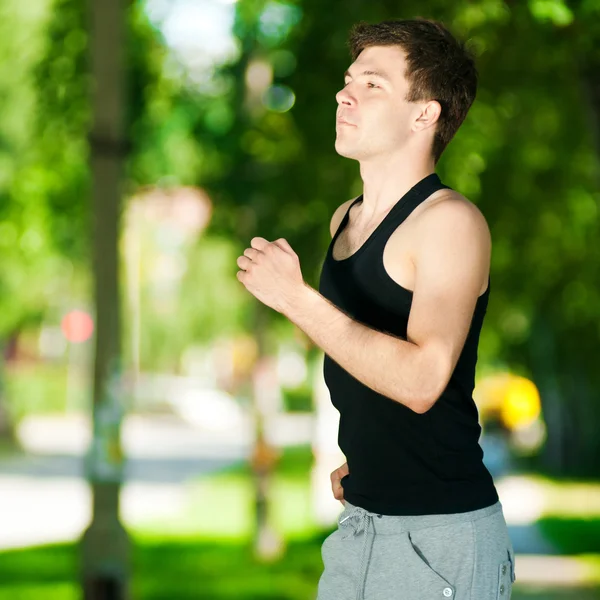 Jeune homme jogging dans le parc — Photo