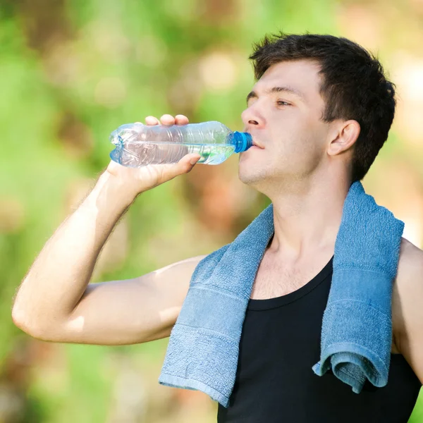 Чоловік п'є воду після фітнесу — стокове фото