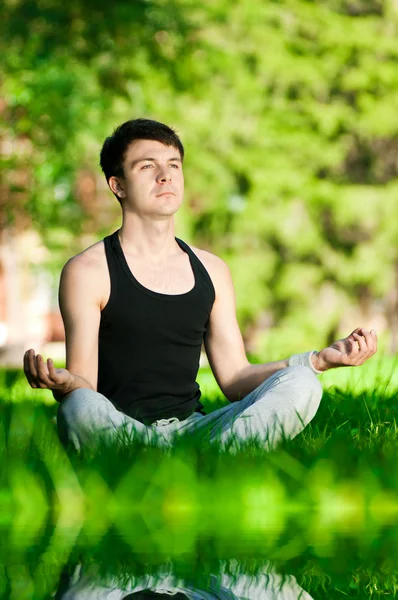 Een jonge man doen yoga oefening — Stockfoto
