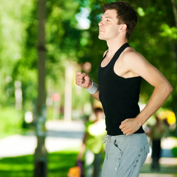 Jonge man joggen in het park — Stockfoto