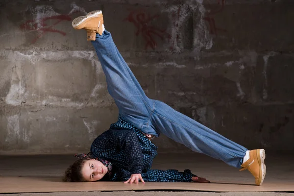 Hip hop tanečnice v moderním stylu, přes cihlovou zeď — Stock fotografie