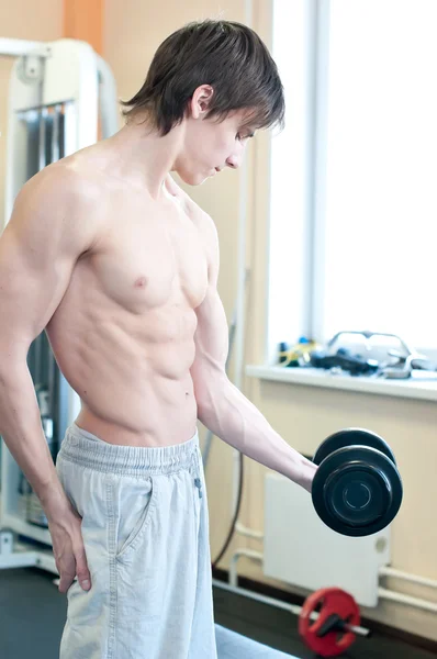 Потужний м'язистий чоловік піднімає ваги в тренажерному залі — стокове фото