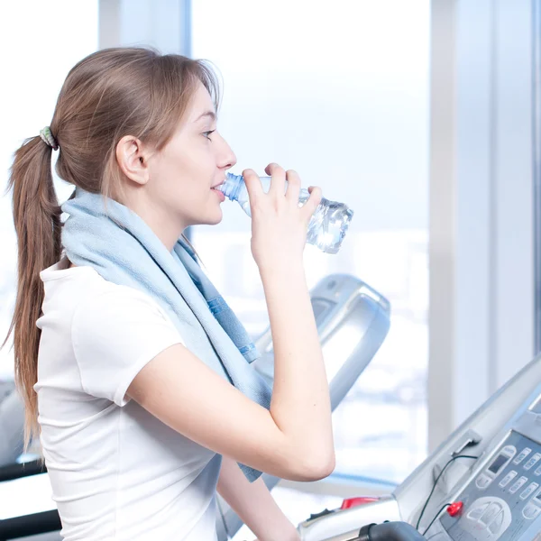 체육관 운동에 여자입니다. 기계와 음료 물에서 실행 — 스톡 사진