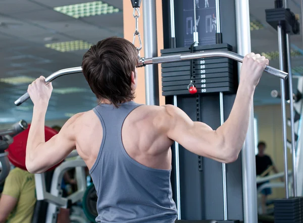 Potente musculoso levantando pesas en el gimnasio — Foto de Stock