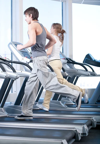 Νεαρή γυναίκα και man σε την άσκηση γυμναστήριο. τρέχει — Φωτογραφία Αρχείου