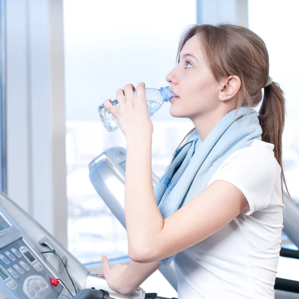 Mujer en el gimnasio bebiendo agua —  Fotos de Stock