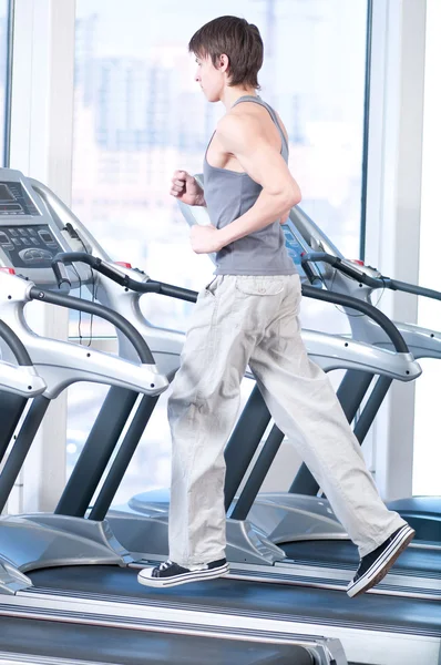 Junger Mann im Fitnessstudio beim Training. Laufen — Stockfoto