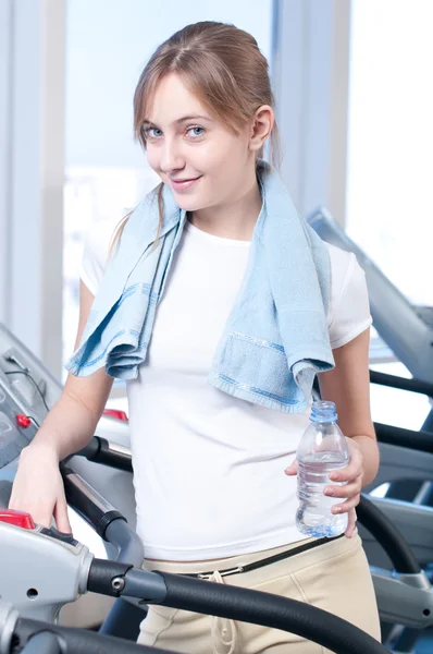 Γυναίκα κατά την άσκηση γυμναστήριο. Εκτελέστε μια μηχανή και ποτό νερό — Φωτογραφία Αρχείου