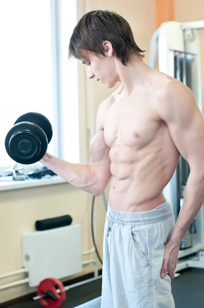 Homme musclé puissant soulevant des poids dans la salle de gym — Photo