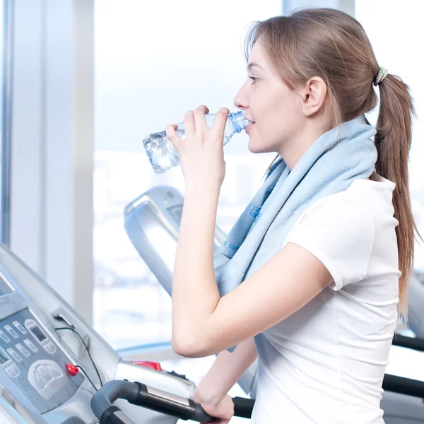 Frau im Fitnessstudio trinkt Wasser — Stockfoto