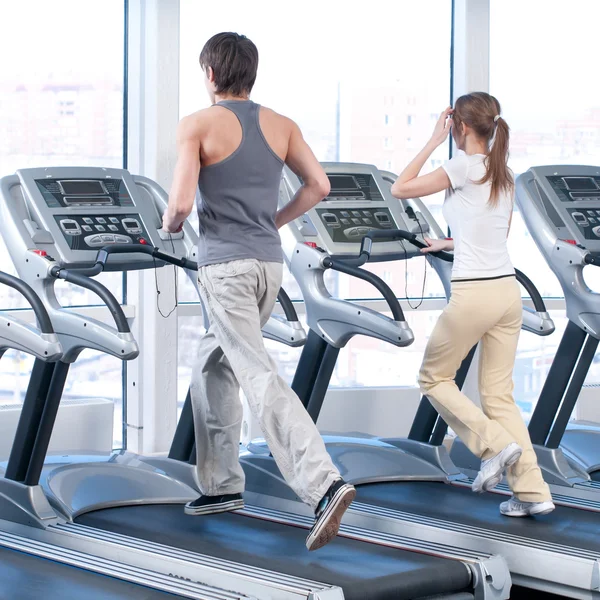 Mladá žena a muž v tělocvičně cvičení. běh — Stock fotografie