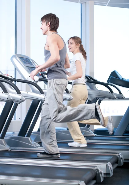 Jovem mulher e homem no ginásio exercício. Correr. — Fotografia de Stock
