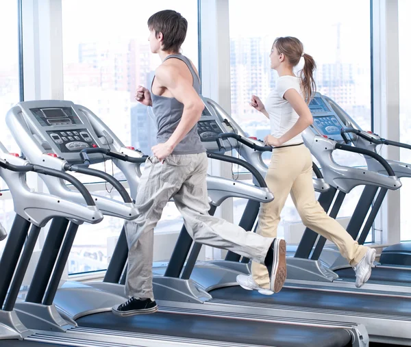 Young woman and man at the gym exercising. Running — Stock Photo, Image