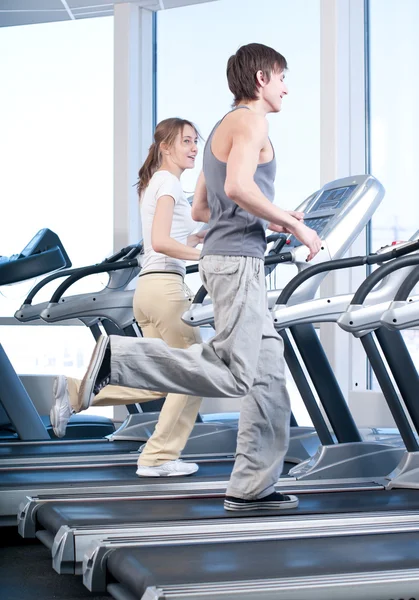 年轻女人和男人在健身房锻炼。运行 — 图库照片