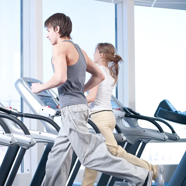 Νεαρή γυναίκα και man σε την άσκηση γυμναστήριο. τρέχει — Φωτογραφία Αρχείου