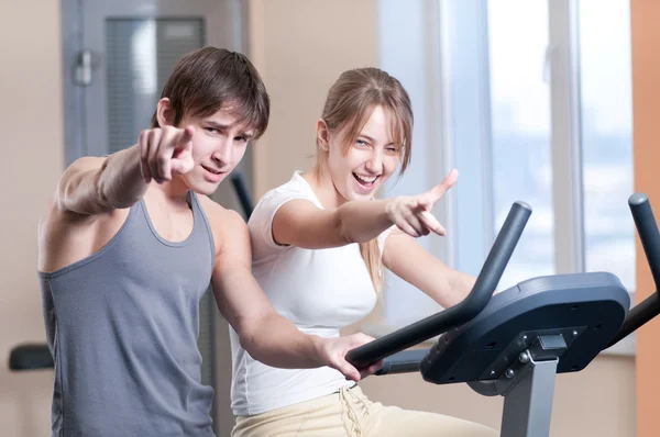 Entraînement sur machine dans un gymnase assisté par un instructeur personnel — Photo