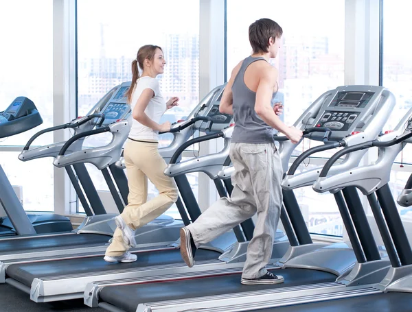 Mujer joven y hombre en el gimnasio haciendo ejercicio. Correr. —  Fotos de Stock