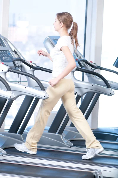 在健身房锻炼的年轻女子。运行 — 图库照片