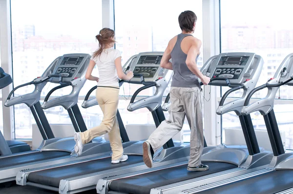 Frau und Mann laufen im Fitnessstudio — Stockfoto