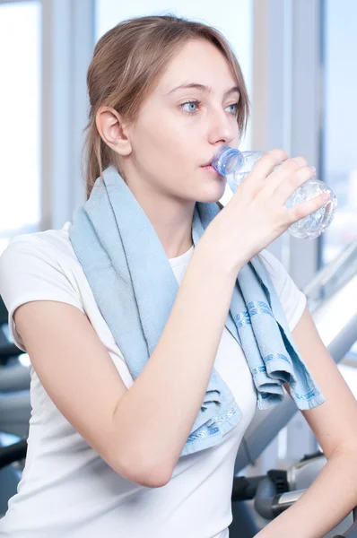 Žena v tělocvičně cvičení. spustit na stroj a pít vodu — Stock fotografie