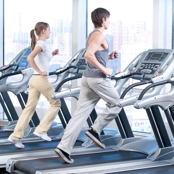 Mujer joven y hombre en el gimnasio haciendo ejercicio. Correr. — Foto de Stock