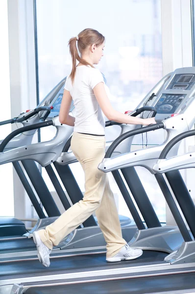 Νεαρή γυναίκα κατά την άσκηση γυμναστήριο. τρέχει — Φωτογραφία Αρχείου