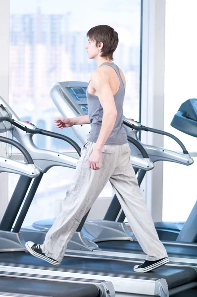 Joven en el gimnasio haciendo ejercicio. Correr. — Foto de Stock