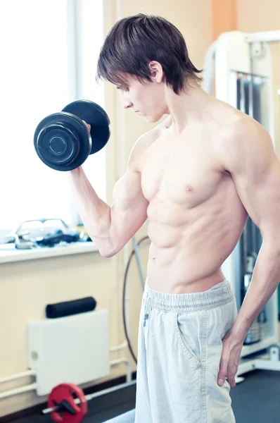 Homme musclé puissant soulevant des poids dans la salle de gym — Photo