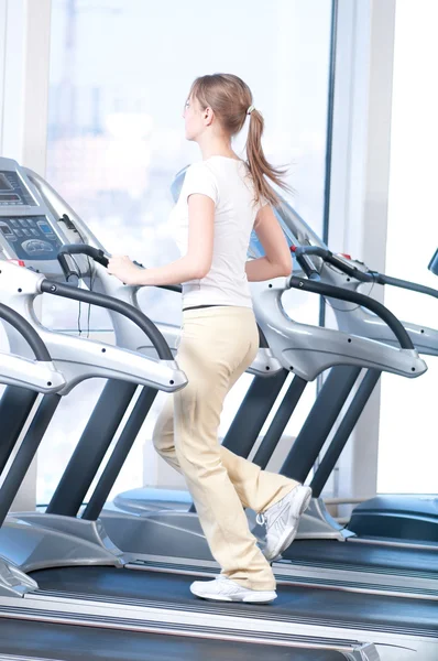 Νεαρή γυναίκα κατά την άσκηση γυμναστήριο. τρέχει — Φωτογραφία Αρχείου