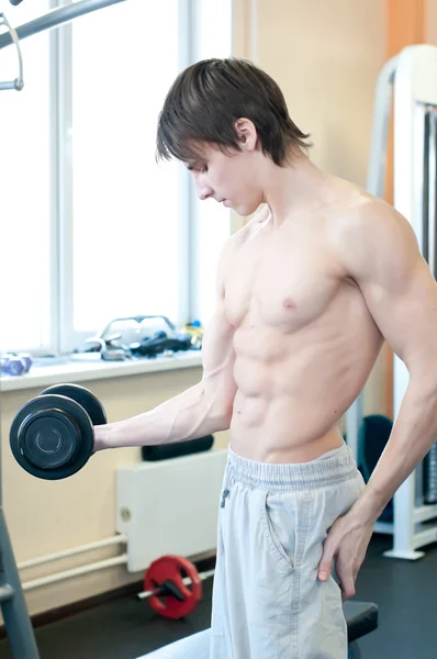 Powerful muscular man lifting weights in gym — Stock Photo, Image