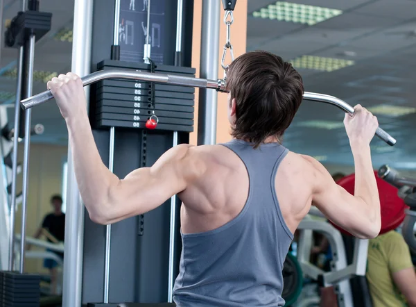 Potente musculoso levantando pesas en el gimnasio — Foto de Stock