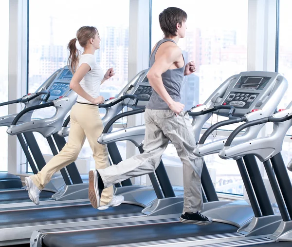 Jovem mulher e homem no ginásio exercício. Correr. — Fotografia de Stock