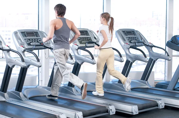 Mujer joven y hombre en el gimnasio haciendo ejercicio. Correr. — Foto de Stock