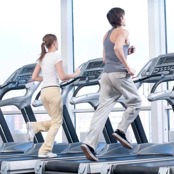 Mladá žena a muž v tělocvičně cvičení. běh — Stock fotografie