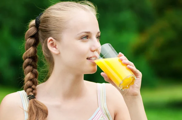Une jeune femme qui boit du jus d'orange. Extérieur — Photo