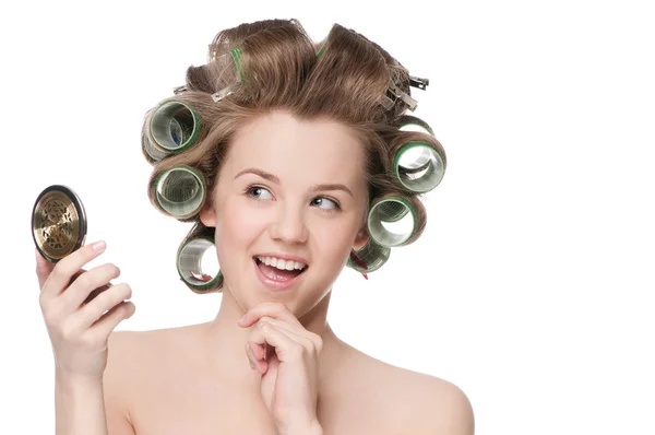 Kobieta w rolki włosy patrząc w lustro — Zdjęcie stockowe