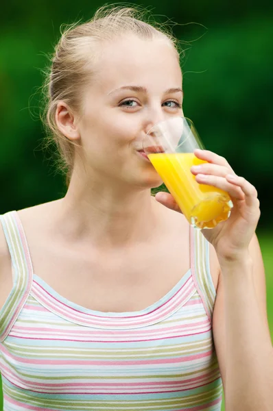 Mujer joven bebiendo jugo de naranja. Exterior — Foto de Stock
