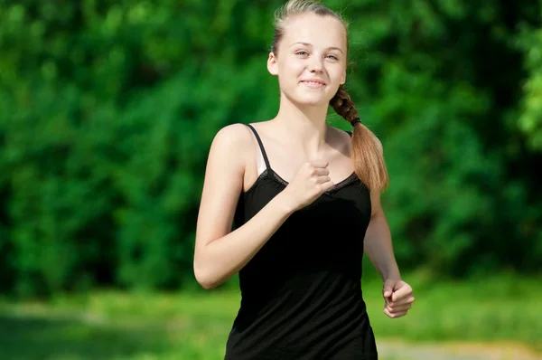 Mujer joven corriendo en el parque verde — Foto de Stock