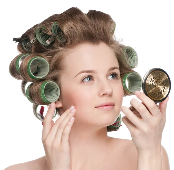 Woman in hair roller looking in mirror — Stock Photo, Image