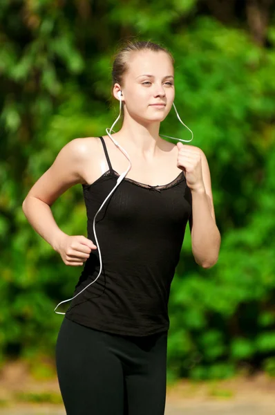 Mujer joven corriendo en el parque verde — Foto de Stock