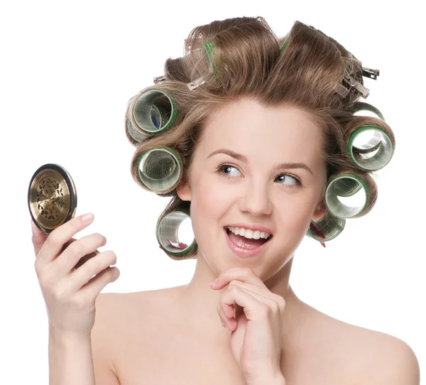 Kobieta w rolki włosy patrząc w lustro — Zdjęcie stockowe