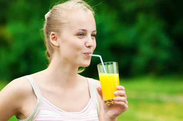 stock image Young woman drinking orange juice. Outdoor