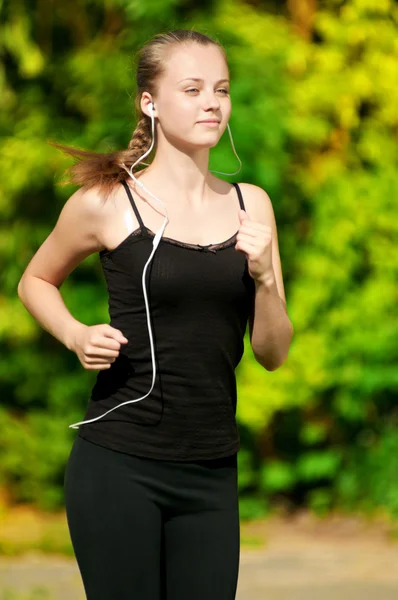 Junge Frau läuft in grünen Park — Stockfoto